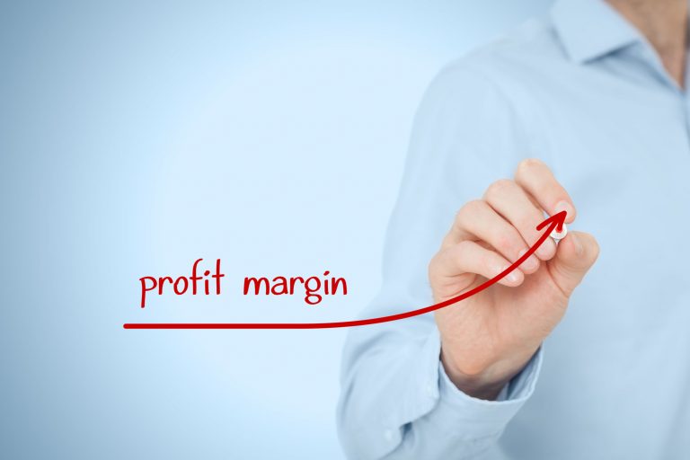 Person drawing an upward red arrow labeled “profit margin” on a transparent screen, symbolizing increasing operating margin and strategic financial performance.
