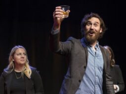 a man presenting at a meeting on a stage with a cocktail in his hand signifying forecast theater