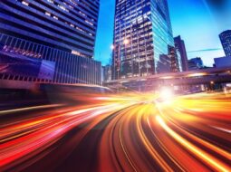 City scape at night where street and car lights are stretched through time to represent organizational speed